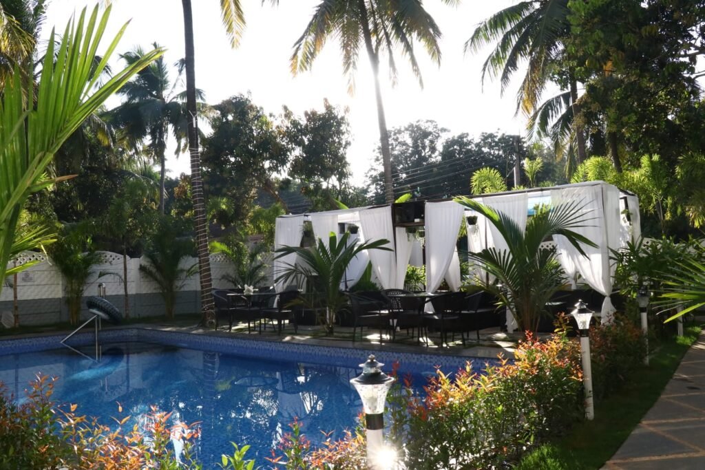 La Vera Boutique Hotel near Mandrem Beach Goa with swimming pool, tropical garden, palm trees, and outdoor seating