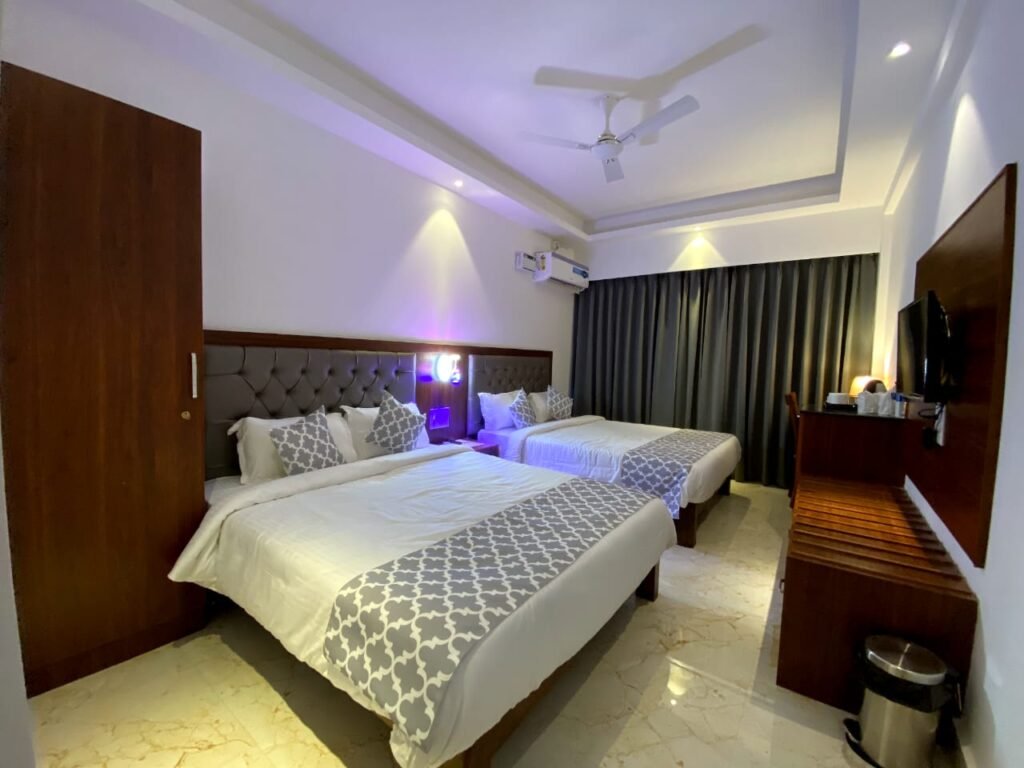 Spacious hotel room near Ashvem Beach Goa with comfortable beds, modern furnishings, air conditioning, and TV