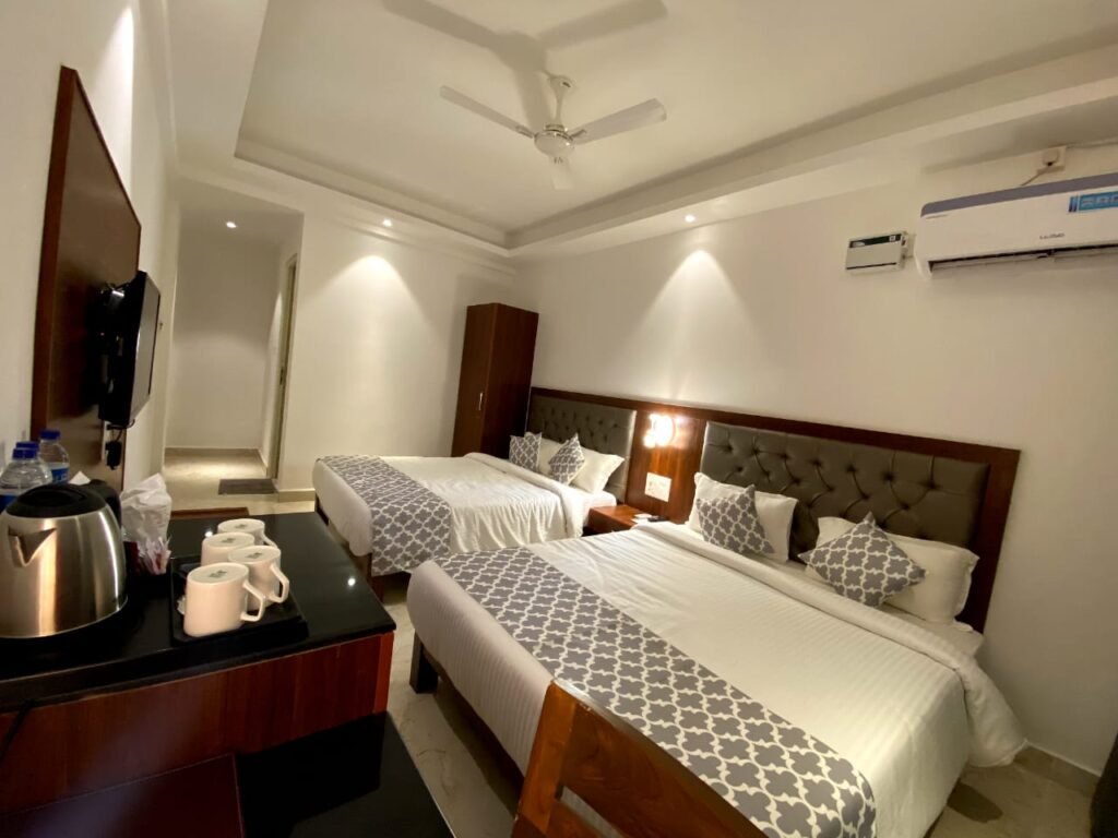 Comfortable hotel room near Ashvem Beach Goa with two beds, air conditioning, and modern furnishings