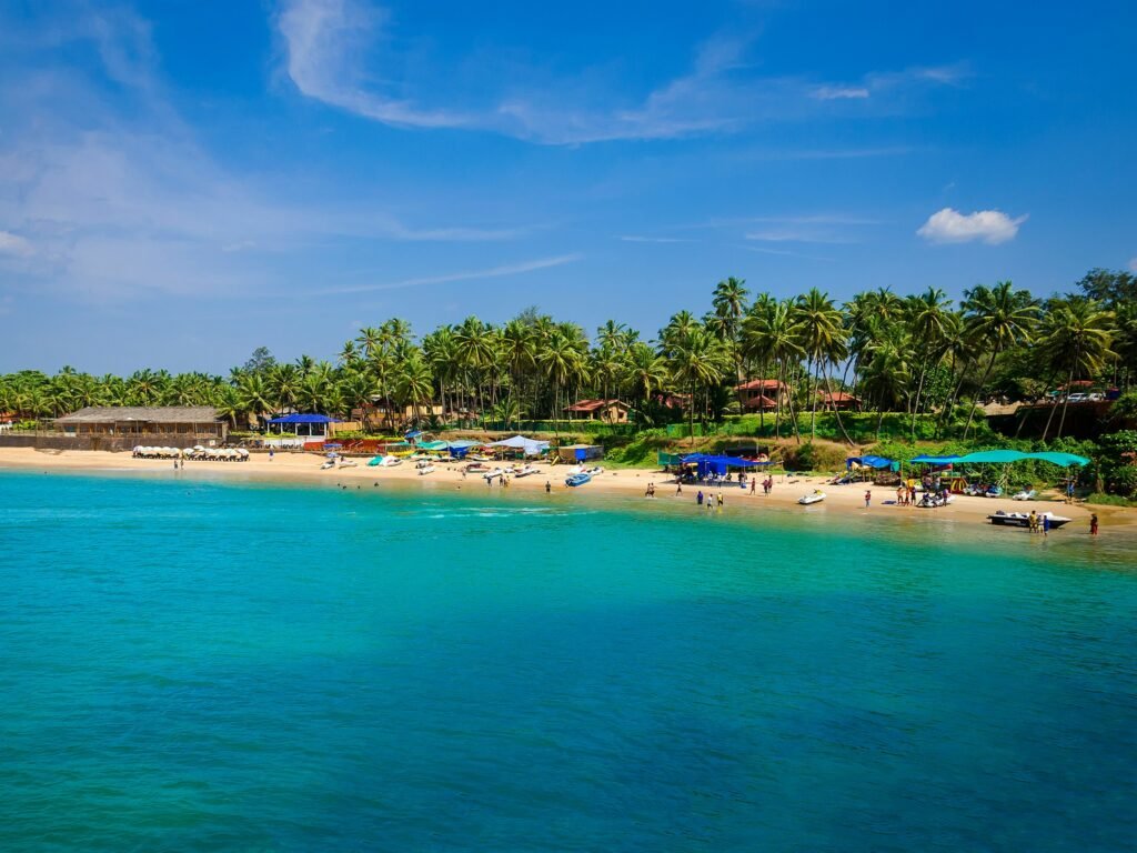 Ashvem Beach Goa with turquoise water, sandy shore, palm trees, and beachside huts